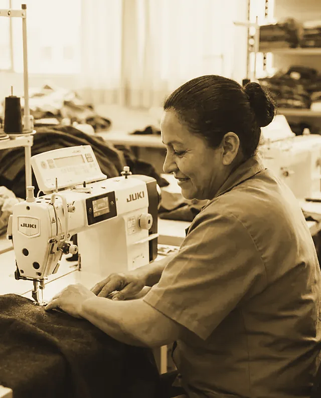 Una costurera sonriendo en su máquina en Medellín