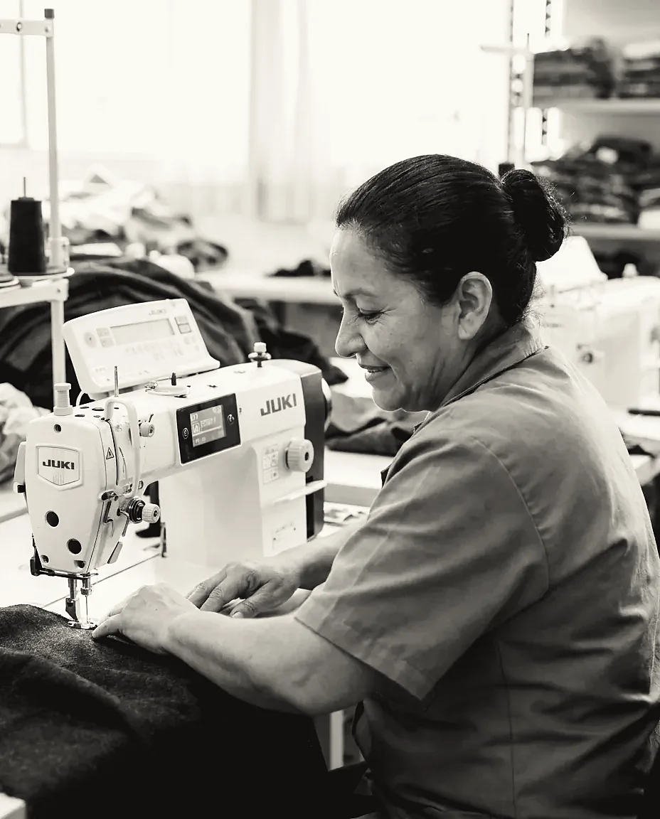 Seamstress at an industrial sewing machine at the Tulum Fashions production plant in Medellín